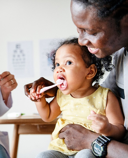 children’s dentist in Collegeville teaching girl how to brush teeth 