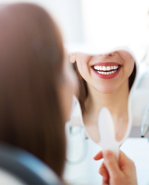 Patient looking at her smile after gum recontouring