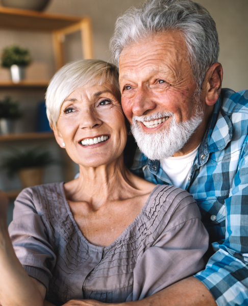 Man and woman smiling after dental implant tooth replacement