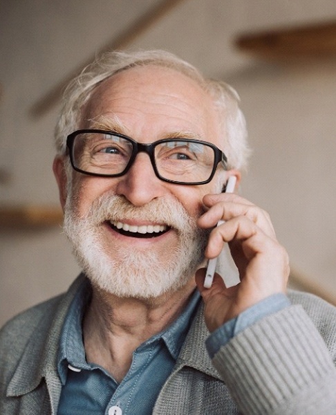 An older man talking on the phone after seeing his dental implant dentist in Collegeville