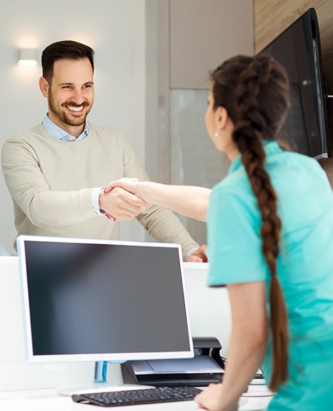 Man checking in at dental office reception desk