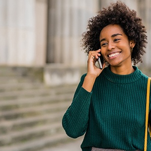 Woman smiling while talking on phone outside