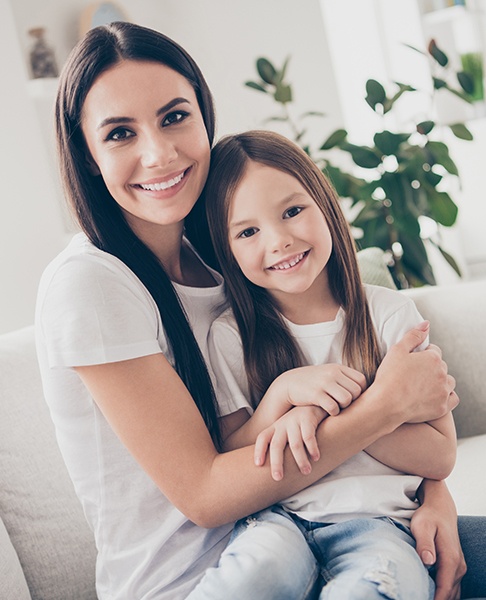 Smiling mother and daughter and dental office for children's dentistry visit