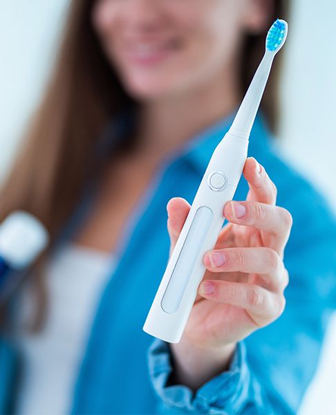 Woman holding an electric toothbrush