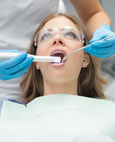 Dentist using intraoral camera to capture images of patient's smile