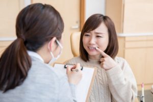 Woman with toothache visiting her emergency dentist