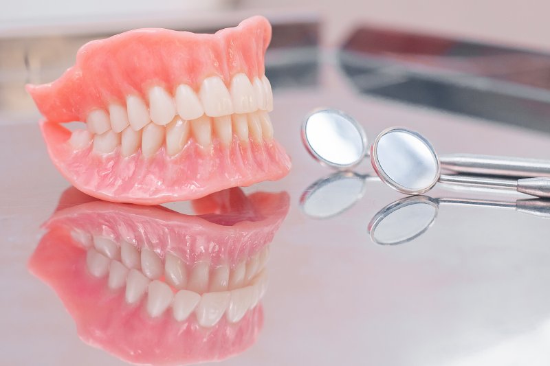 a set of full dentures and dental instruments sitting on a table