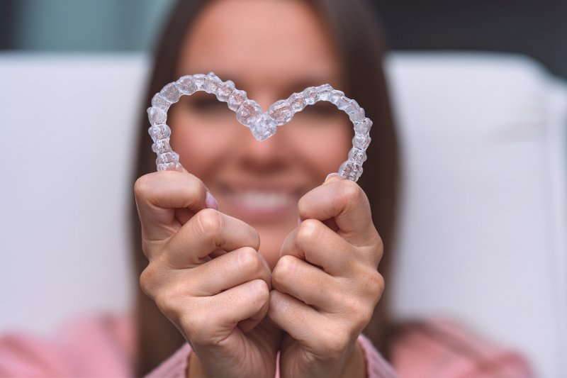 person making heart with Invisalign aligners