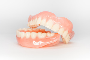 Two full dentures sitting on white surface